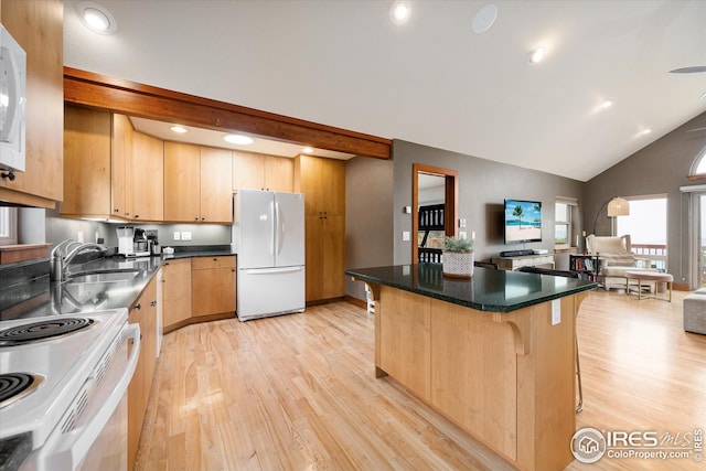 kitchen featuring white appliances, sink, a center island, a kitchen bar, and light hardwood / wood-style floors