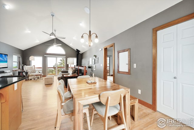 dining space featuring ceiling fan with notable chandelier, light hardwood / wood-style flooring, and lofted ceiling