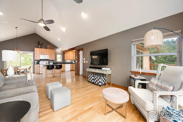 living room with light hardwood / wood-style floors, sink, high vaulted ceiling, and ceiling fan