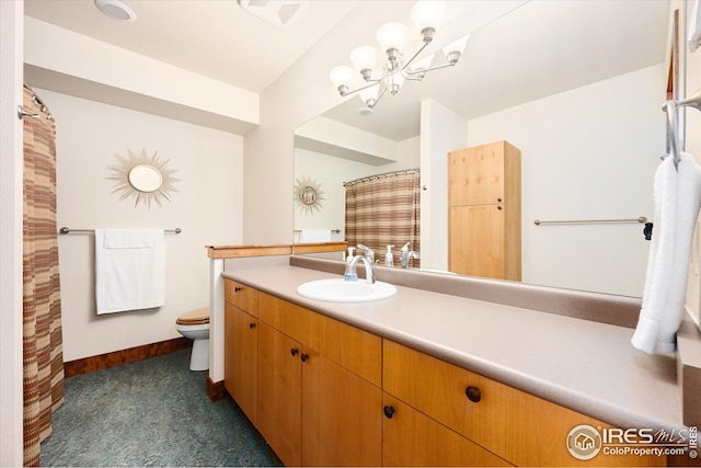 bathroom featuring an inviting chandelier, vanity, and toilet