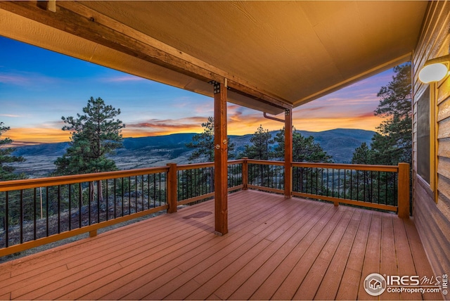 deck at dusk featuring a mountain view