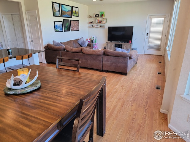 dining space with ceiling fan and light hardwood / wood-style flooring