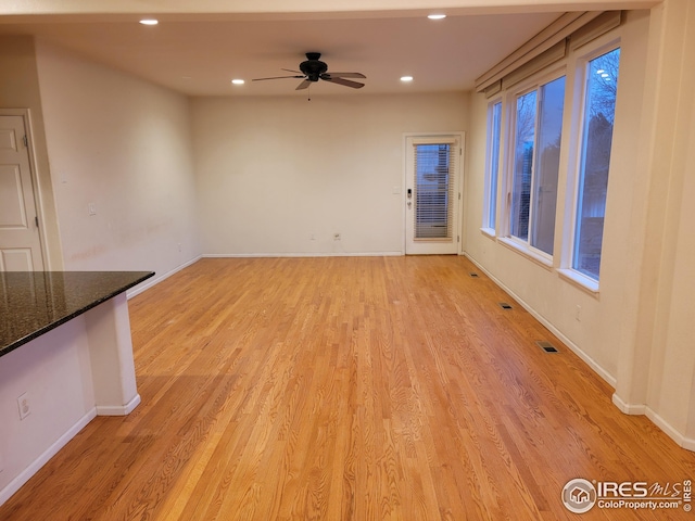 unfurnished living room with ceiling fan and light wood-type flooring