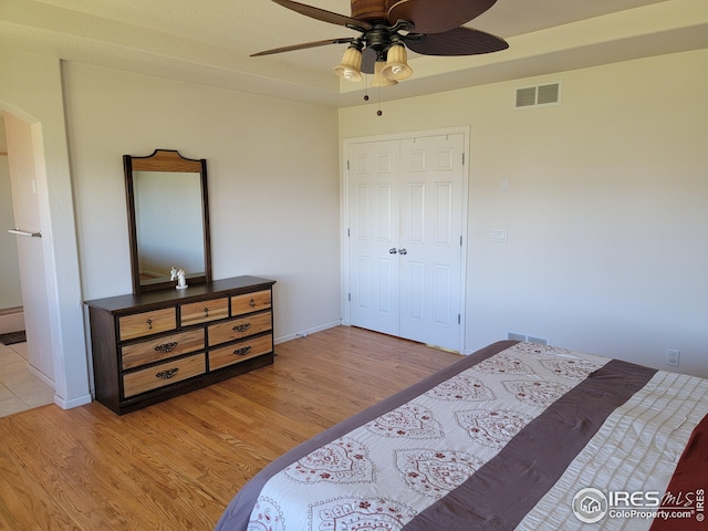 bedroom featuring ceiling fan, a closet, and light hardwood / wood-style flooring