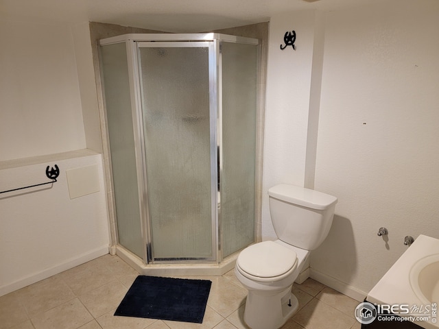 bathroom featuring tile patterned floors, a shower with door, vanity, and toilet