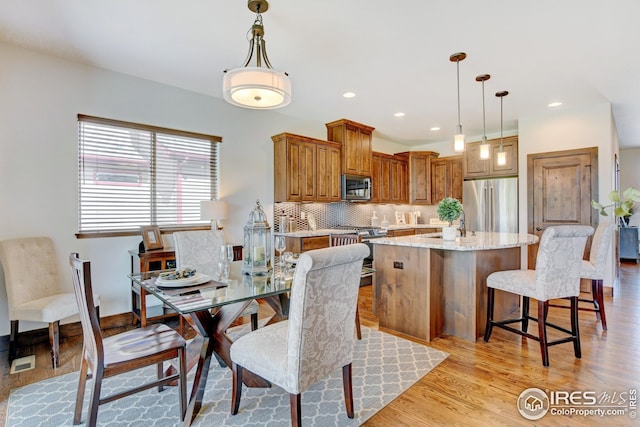 dining area with sink and light hardwood / wood-style flooring