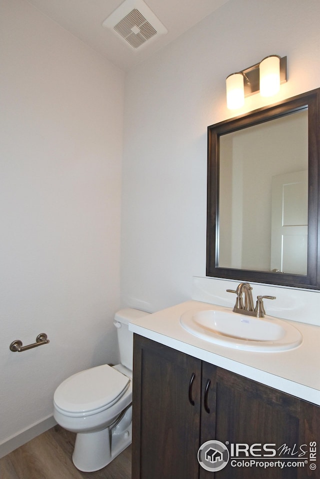 bathroom featuring hardwood / wood-style floors, vanity, and toilet