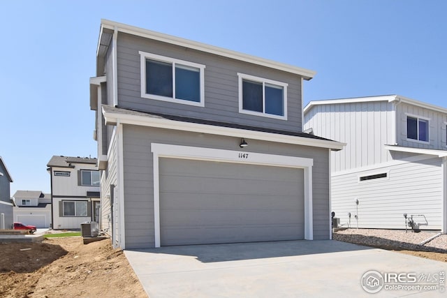 view of front of home with a garage and central air condition unit