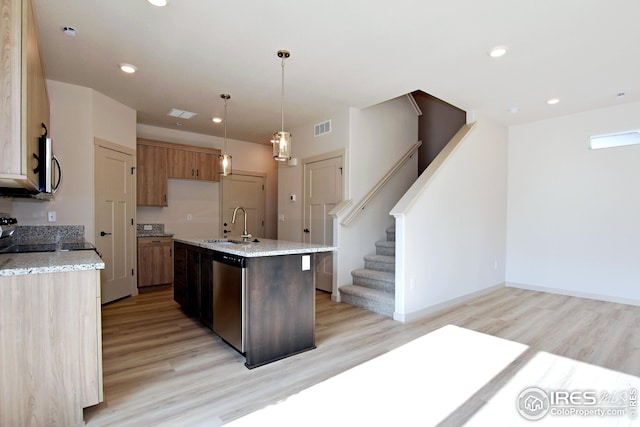 kitchen with stainless steel appliances, sink, light wood-type flooring, an island with sink, and hanging light fixtures