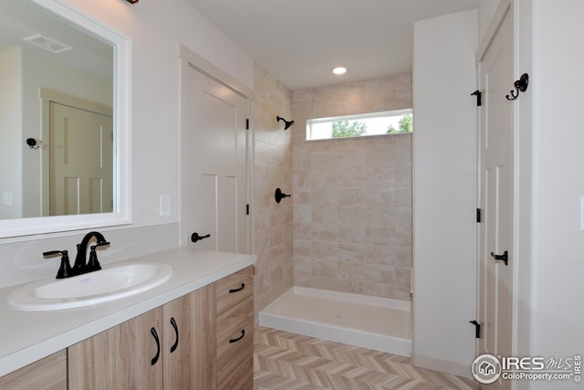 bathroom with vanity and tiled shower