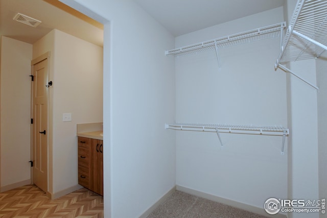 spacious closet featuring light parquet floors