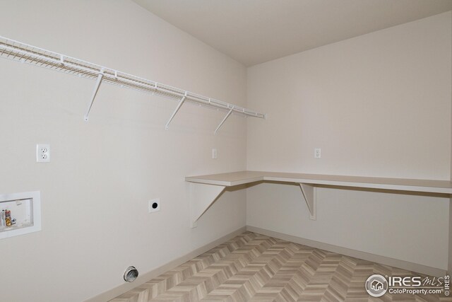 clothes washing area featuring hookup for a washing machine, electric dryer hookup, and light parquet flooring