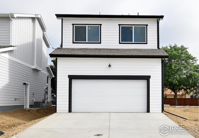 view of front of home with central air condition unit and a garage