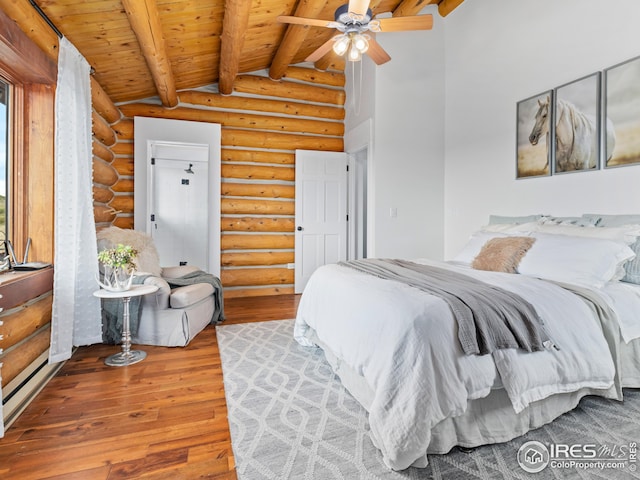 bedroom featuring log walls, beam ceiling, hardwood / wood-style floors, wood ceiling, and ceiling fan