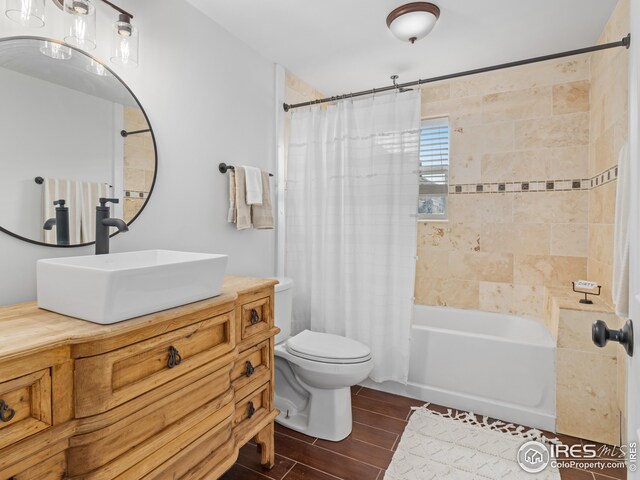 full bathroom featuring shower / bath combination with curtain, vanity, and toilet