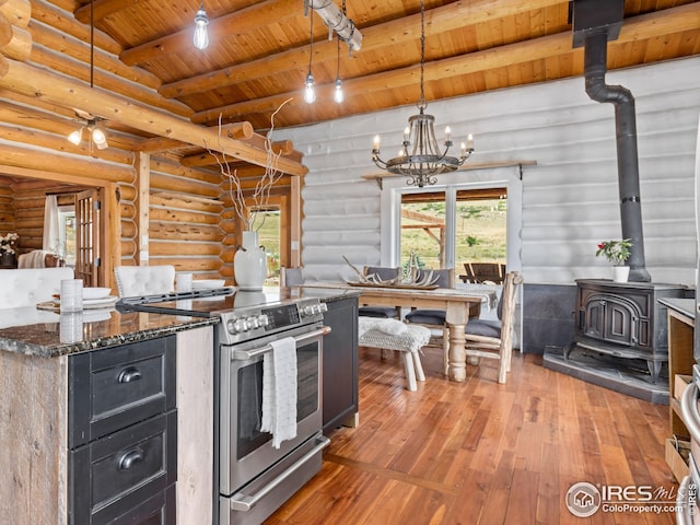 kitchen featuring high end stove, wood ceiling, a wood stove, and log walls