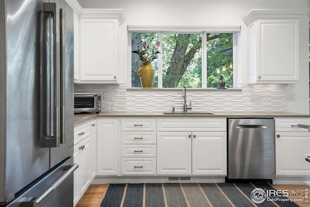 2870 18th St, Boulder, CO 80304 - kitchen with white cabinetry, wood-type flooring, sink, appliances with stainless steel finishes, and backsplash