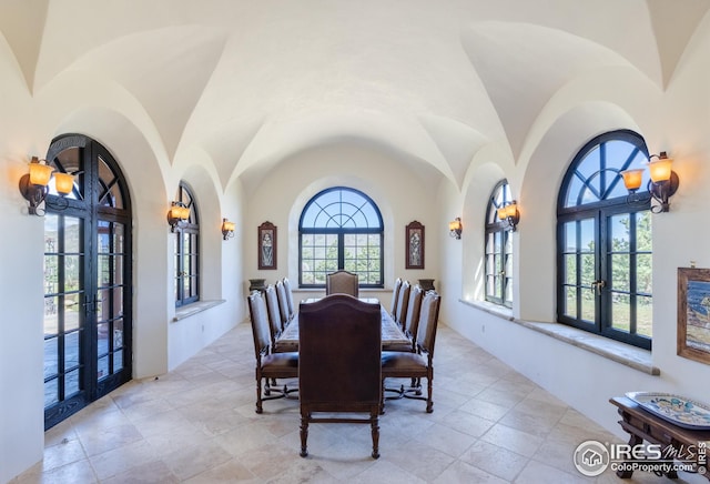 dining room with lofted ceiling, french doors, and a notable chandelier