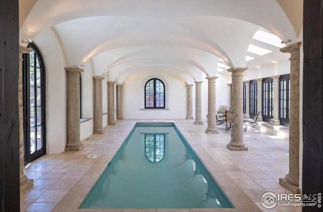 view of pool with a hot tub and decorative columns