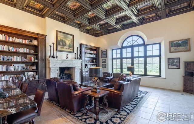 living room with coffered ceiling and light tile patterned flooring