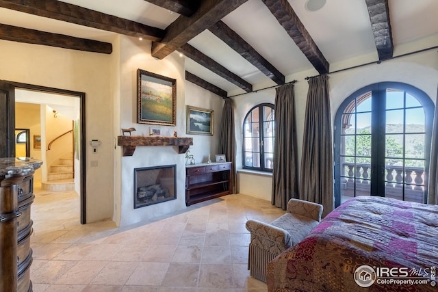 bedroom with connected bathroom, french doors, and lofted ceiling with beams