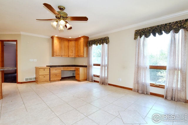 kitchen featuring light tile patterned flooring, ceiling fan, ornamental molding, and built in desk