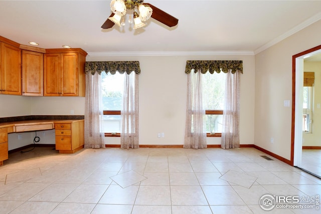 interior space featuring crown molding, built in desk, ceiling fan, and light tile patterned floors