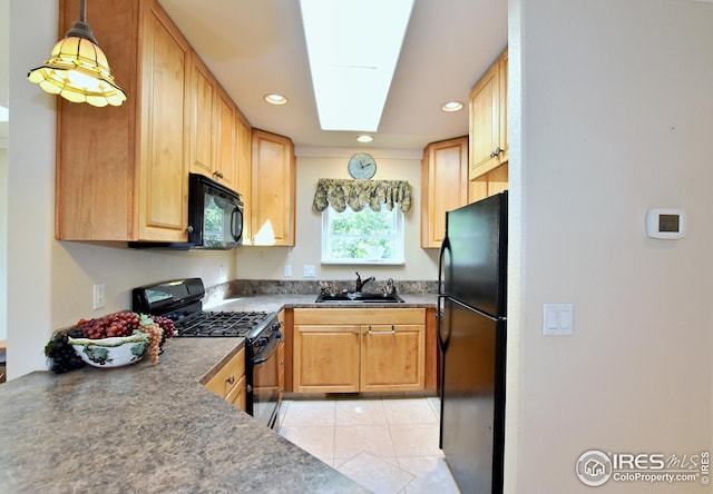 kitchen with sink, light tile patterned floors, a skylight, black appliances, and decorative light fixtures