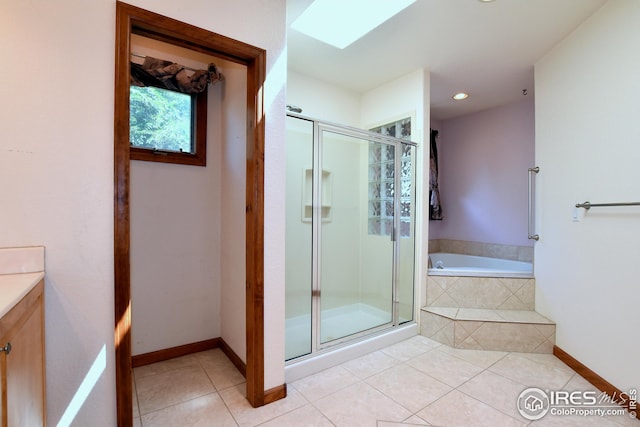 bathroom featuring vanity, a skylight, tile patterned floors, and plus walk in shower