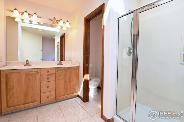 bathroom featuring walk in shower, vanity, toilet, and tile patterned flooring