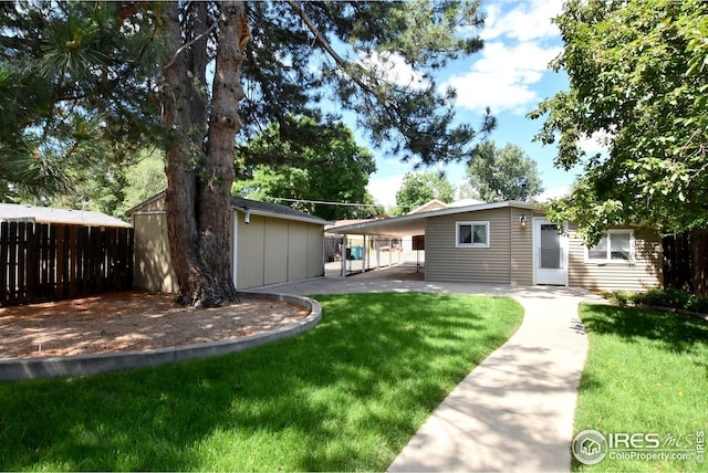 rear view of property featuring a yard and a carport