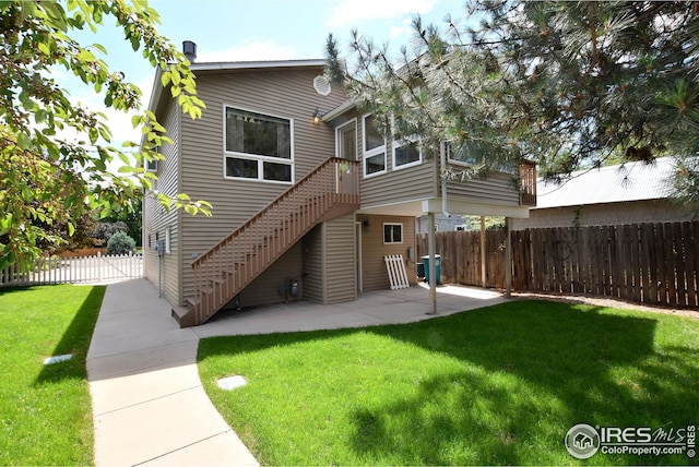 rear view of property with a lawn and a patio area