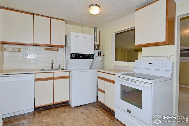 kitchen with stacked washer and dryer, white appliances, sink, light parquet floors, and white cabinets