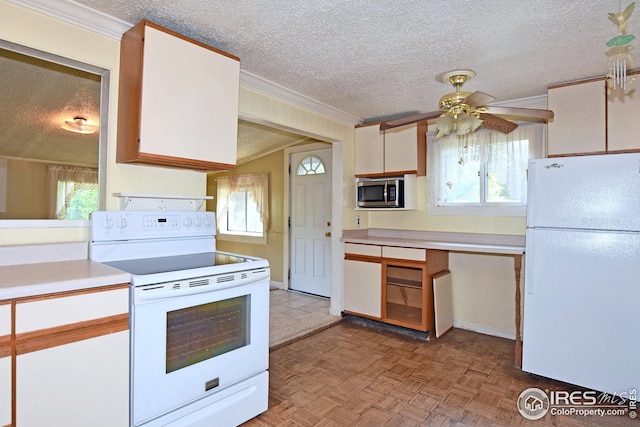 kitchen with white appliances, crown molding, white cabinetry, a textured ceiling, and light parquet flooring