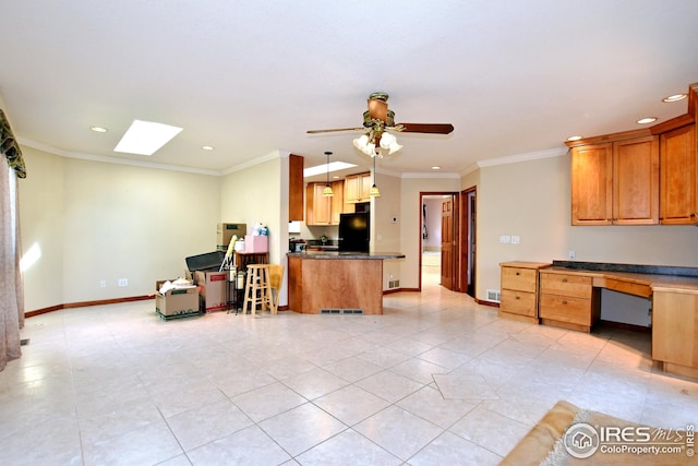 kitchen with black refrigerator, ornamental molding, decorative light fixtures, and built in desk