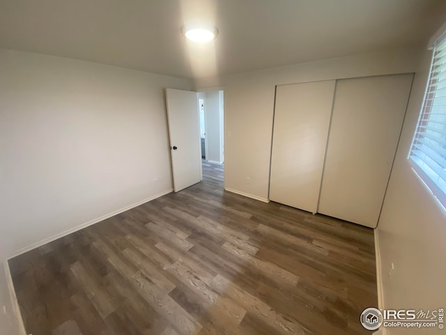 unfurnished bedroom with hardwood / wood-style flooring and a closet