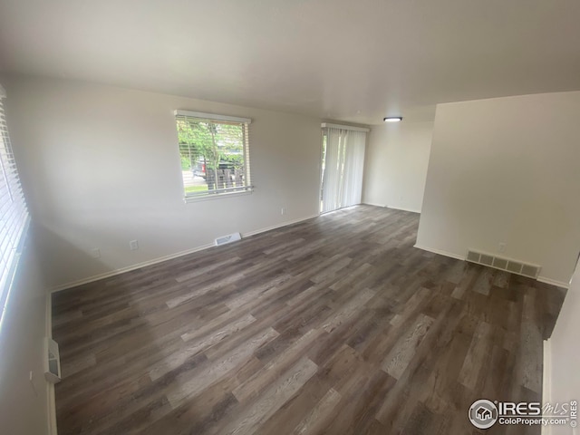 empty room with dark hardwood / wood-style flooring