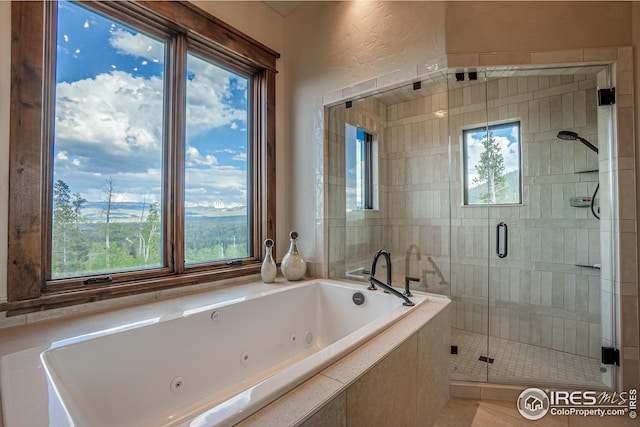 300 Samaia Ct, Tabernash, CO 80478 - bathroom with a whirlpool tub, a textured wall, a shower stall, and a wealth of natural light