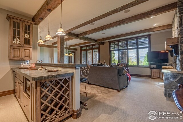 300 Samaia Ct, Tabernash, CO 80478 - kitchen featuring beam ceiling, light colored carpet, open floor plan, a peninsula, and a kitchen breakfast bar