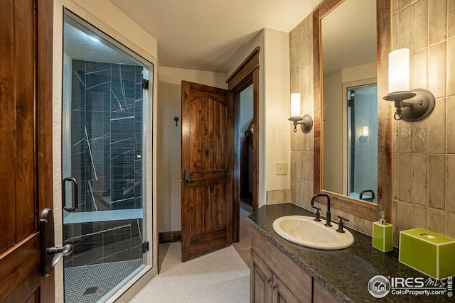 300 Samaia Ct, Tabernash, CO 80478 - bathroom featuring tasteful backsplash, a shower stall, vanity, and tile walls
