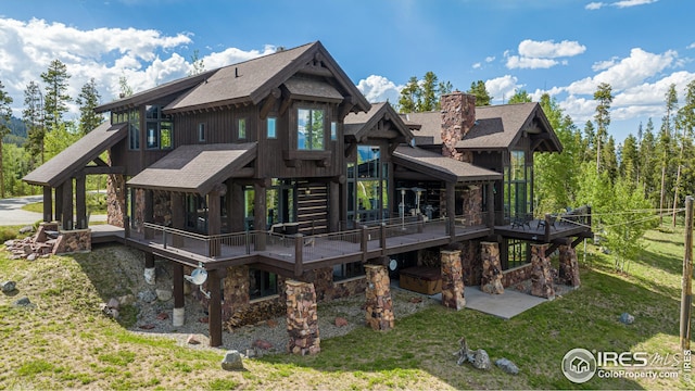 300 Samaia Ct, Tabernash, CO 80478 - back of property with a lawn, stone siding, a chimney, a wooden deck, and board and batten siding