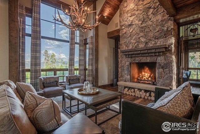 300 Samaia Ct, Tabernash, CO 80478 - unfurnished living room with high vaulted ceiling, a stone fireplace, wood finished floors, and a wealth of natural light