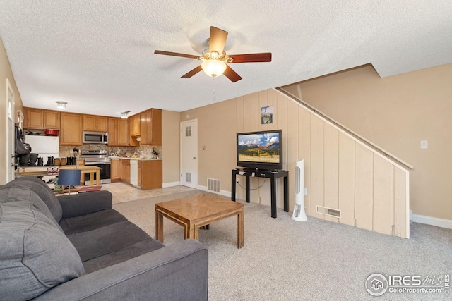 carpeted living room with a textured ceiling and ceiling fan