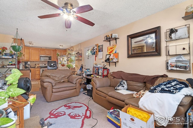 carpeted living room featuring ceiling fan and a textured ceiling