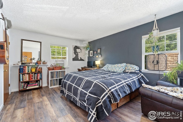 bedroom featuring dark hardwood / wood-style flooring and a textured ceiling