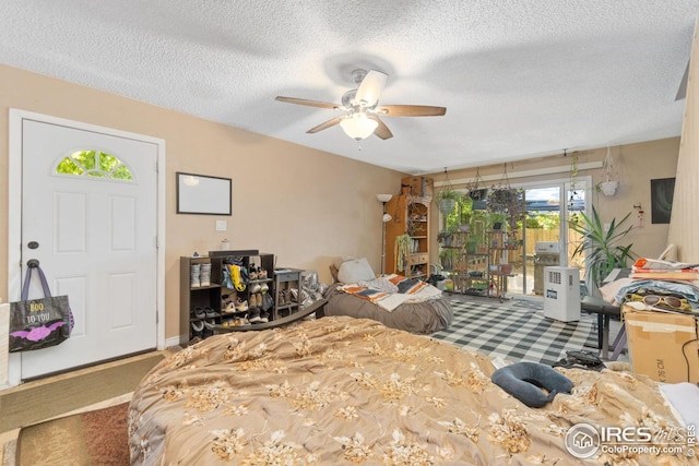 carpeted bedroom featuring ceiling fan, access to exterior, and a textured ceiling