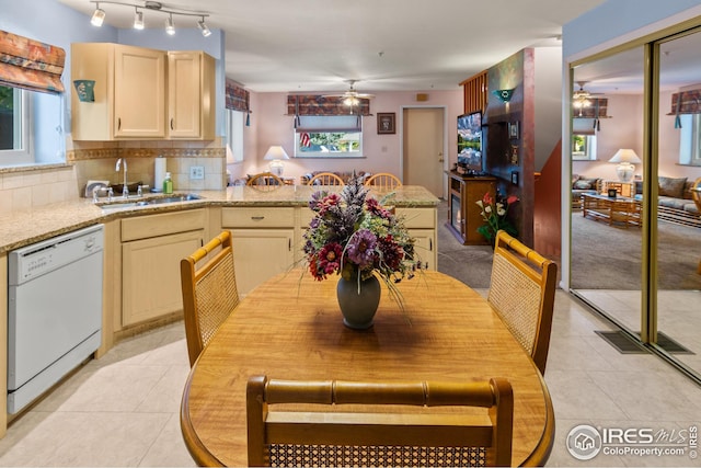 tiled dining space with ceiling fan and sink