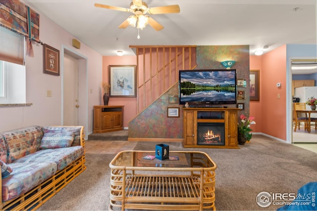 living room with ceiling fan, light colored carpet, and a fireplace