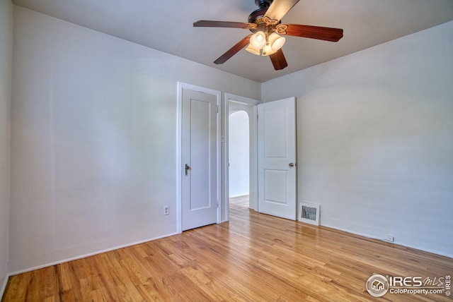 empty room with light wood-style floors, visible vents, and baseboards