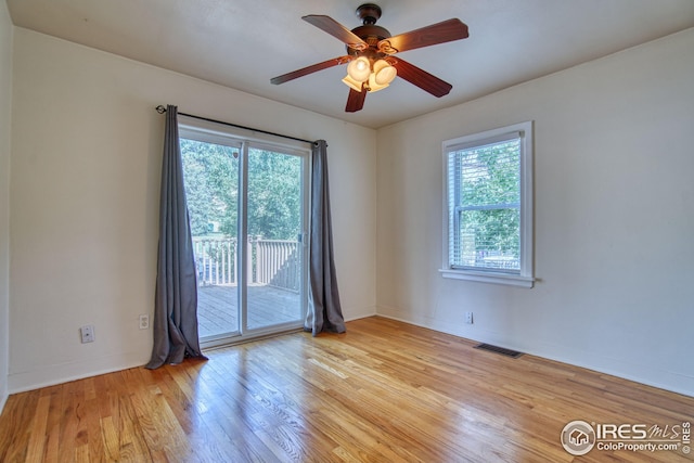 empty room featuring light wood finished floors, baseboards, visible vents, and ceiling fan